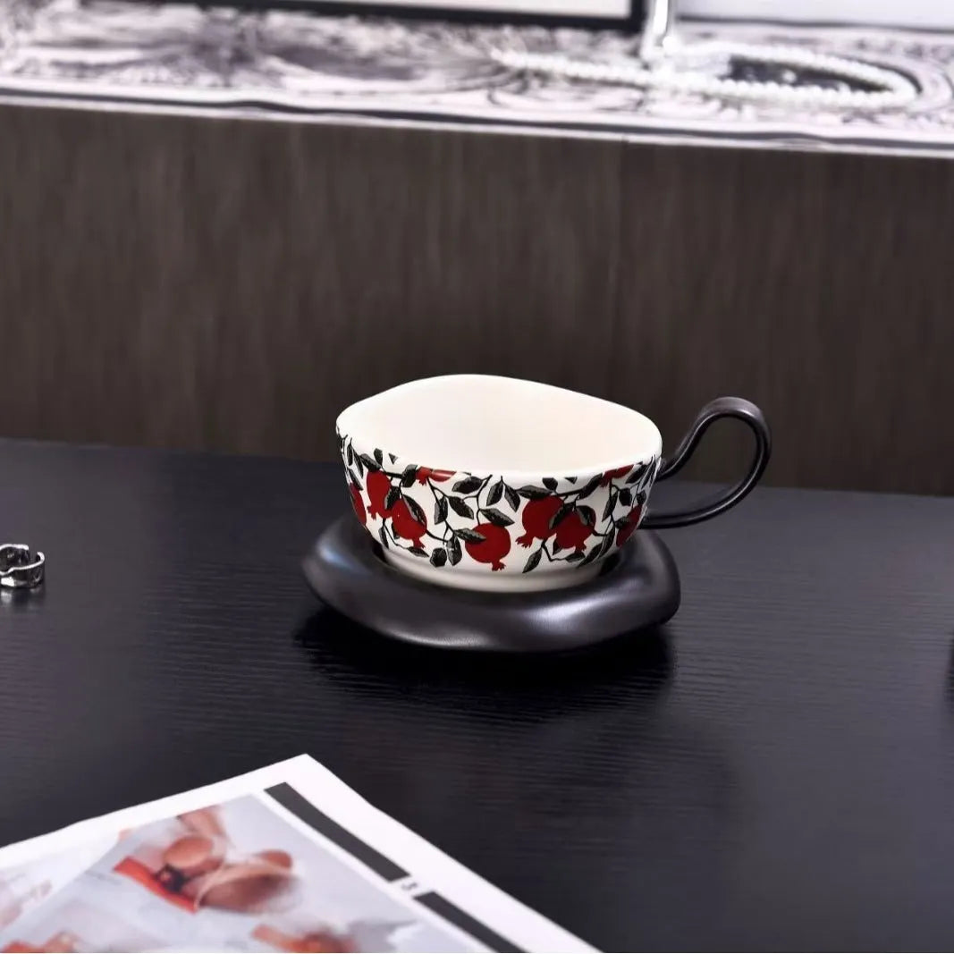 Antique-style black ceramic coffee cup and saucer set on a wooden table