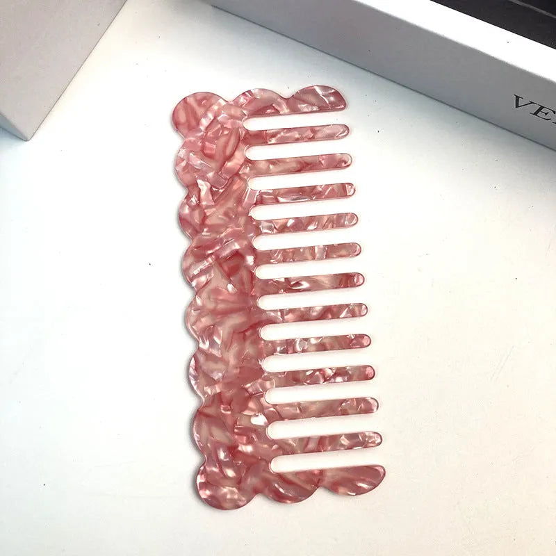 Acetate geometric wave hairdressing comb in pink on white background, 12 cm length