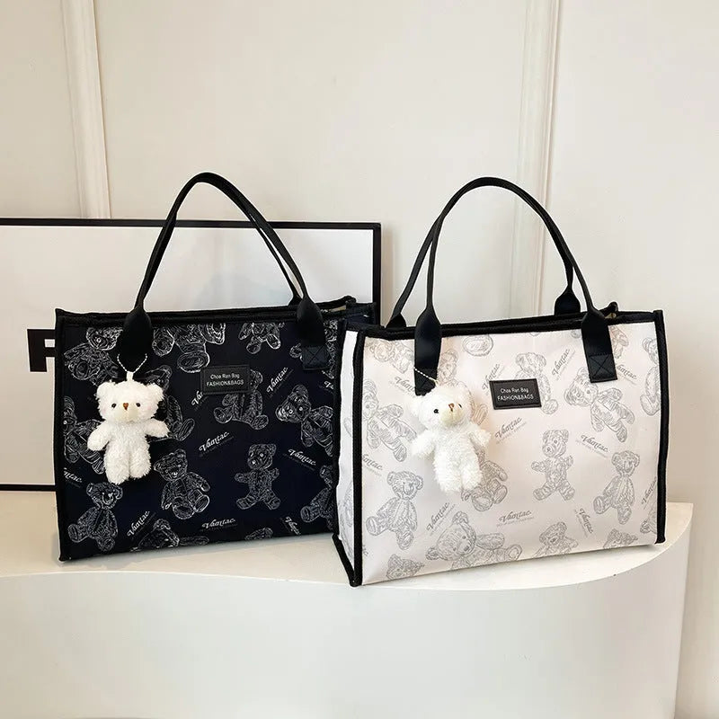 Women's black and white printed canvas tote bag with sandwich pocket and large capacity.