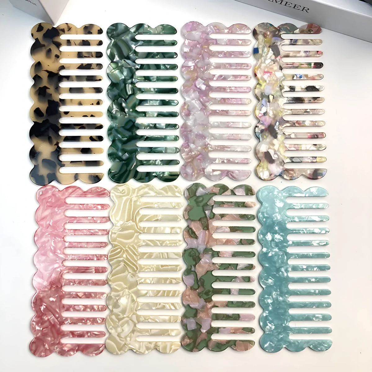 Acetate geometric wave hairdressing comb in pink on white background, 12 cm length