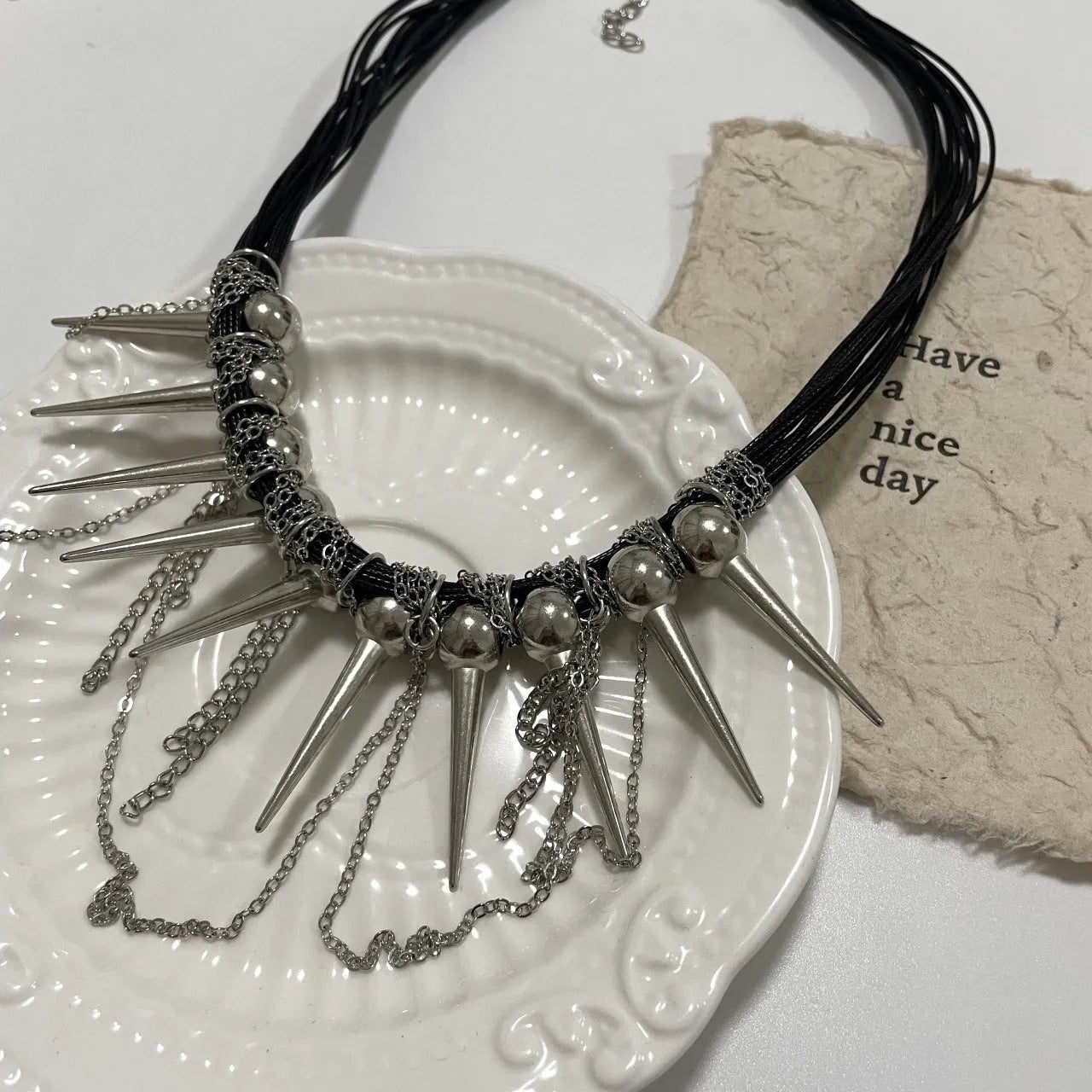 Leather necklace with round beads, a winding tassel, and point rivets in an electroplated picture colour.