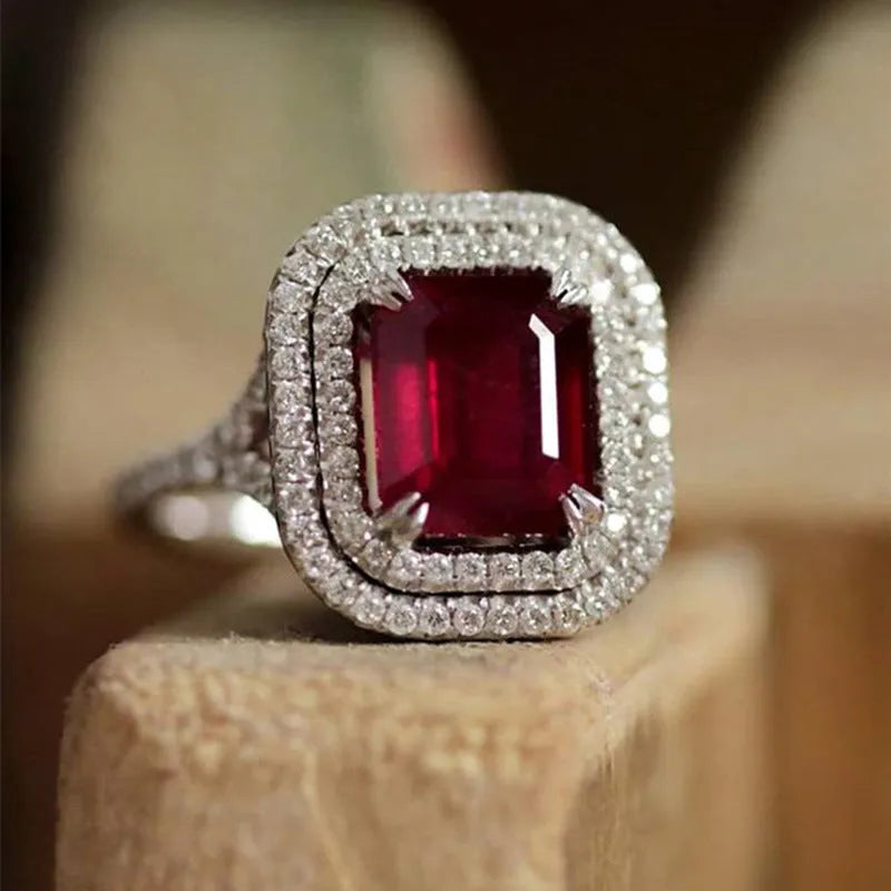 Women's copper square ring with a large red rhinestone centre on a hand.