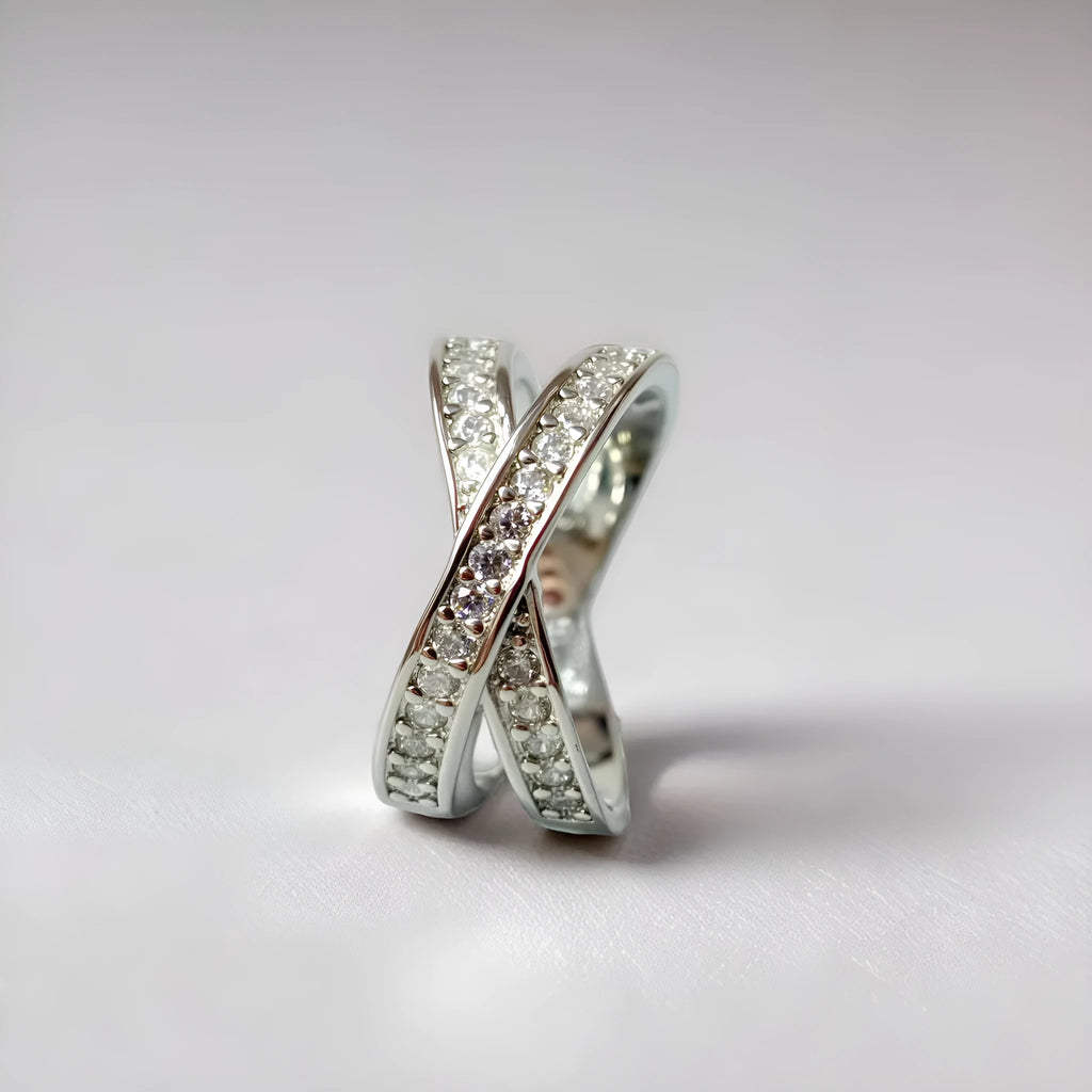 Metal ring with cross design and zircon detail in silver or rose gold finish.