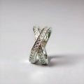 Metal ring with cross design and zircon detail in silver or rose gold finish.