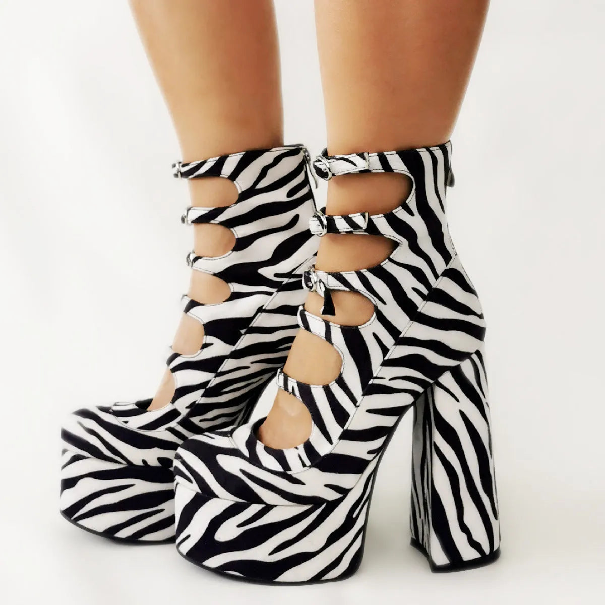 Black women's ankle boot with platform heel, thick sole, and a serpentine strap with buckle closure.