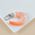 White PVC shrimp simulation keychain with metal door buckle, shown from the side to highlight its 1.5cm thickness.