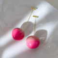 A pair of lightweight acrylic earrings shaped like peaches, shown in small and large size options.
