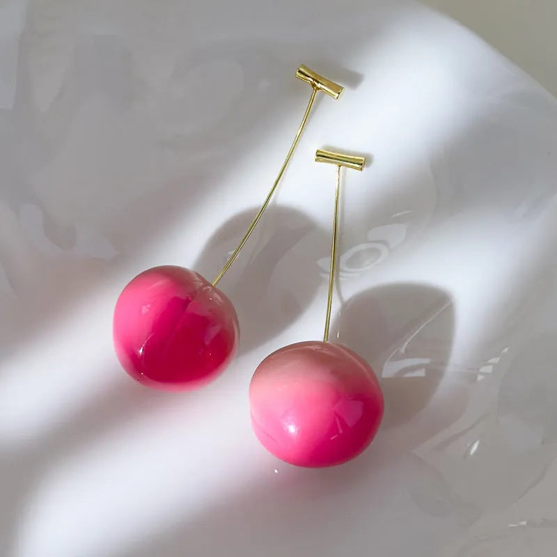 A pair of lightweight acrylic earrings shaped like peaches, shown in small and large size options.