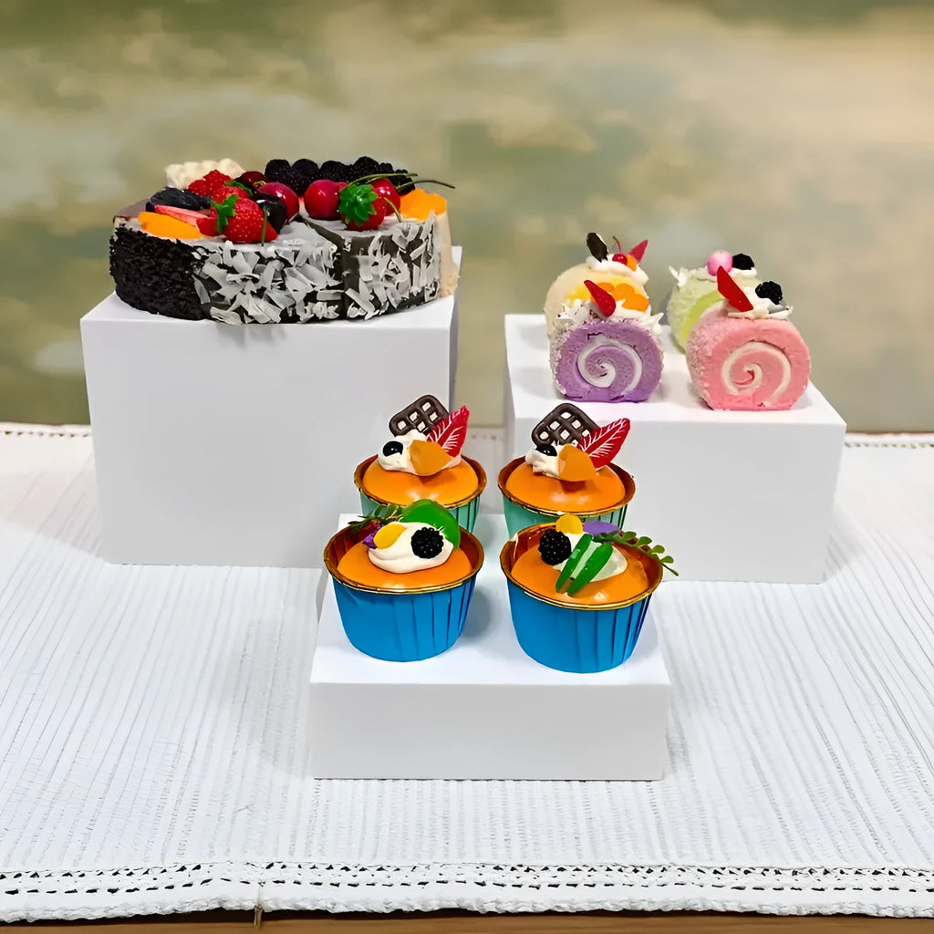 White plastic cube dessert display stand set of six pieces arranged on a table.