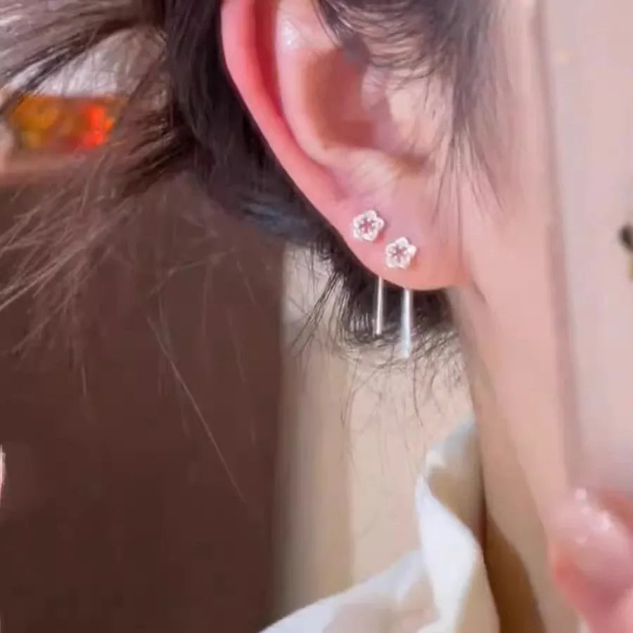 Silver hollow flower hanging earrings with detailed petal design and needle silver construction