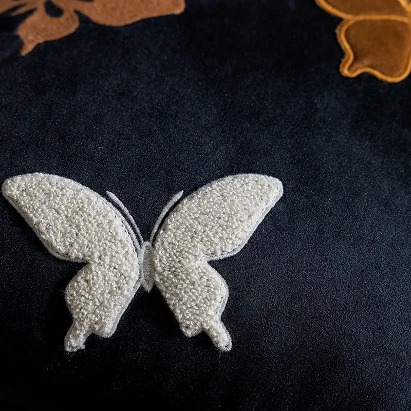 Square decorative cushion with Chinese butterfly embroidery in beige, black, and purple threads.