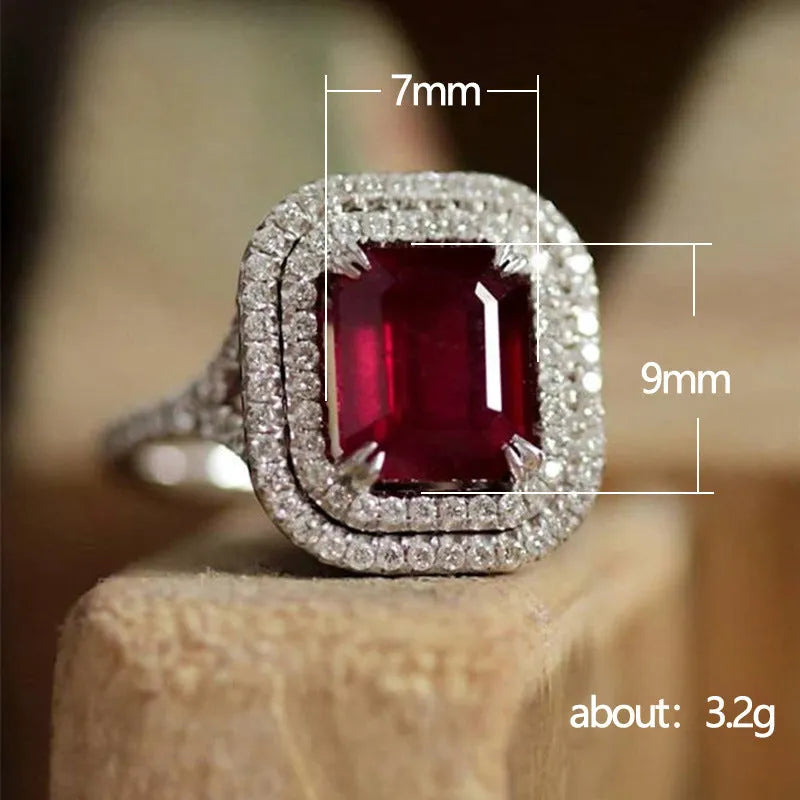 Women's copper square ring with a large red rhinestone centre on a hand.
