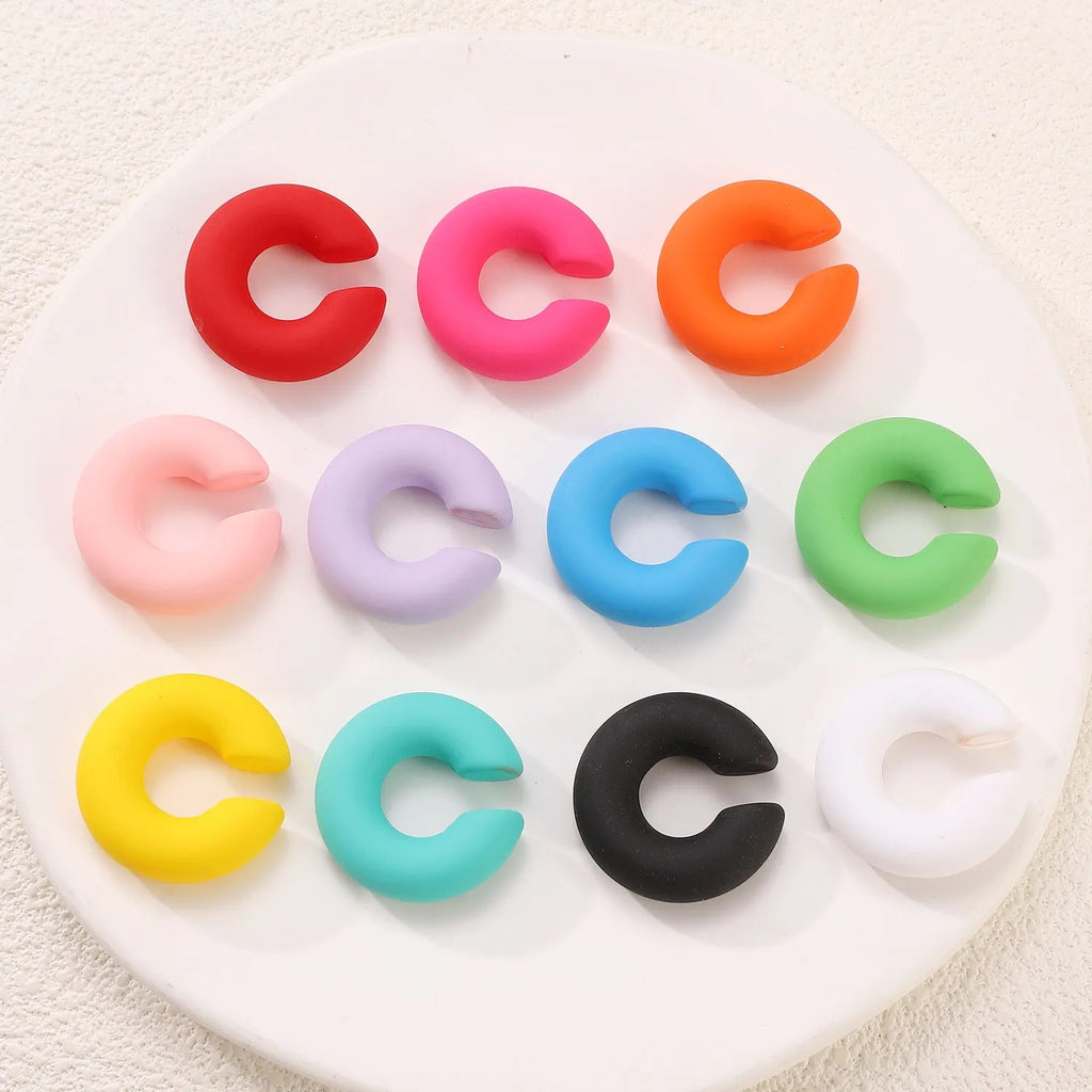 A pair of matte finish, coarse round C-shaped clip-on earrings for women in a choice of fifteen candy colours.