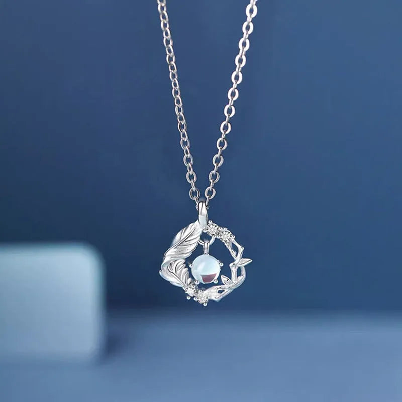 Geometric tree and bird pendant necklace for women with an adjustable chain in a blue eucalyptus colour.