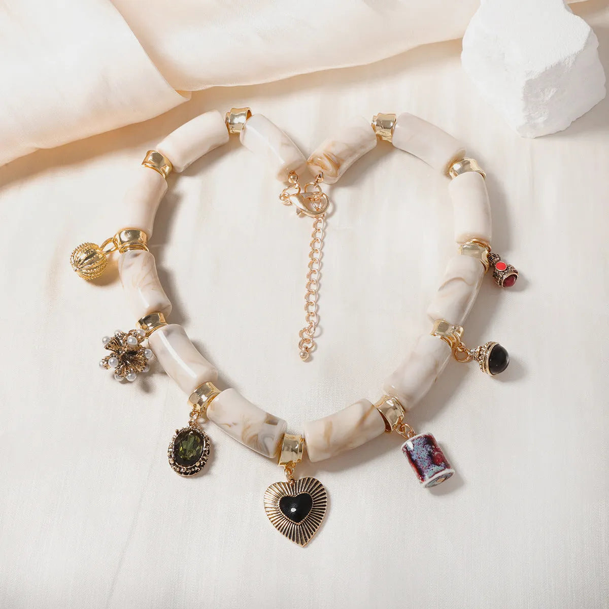Heart-shaped resin and plastic pendant necklace with an electroplated finish for women.