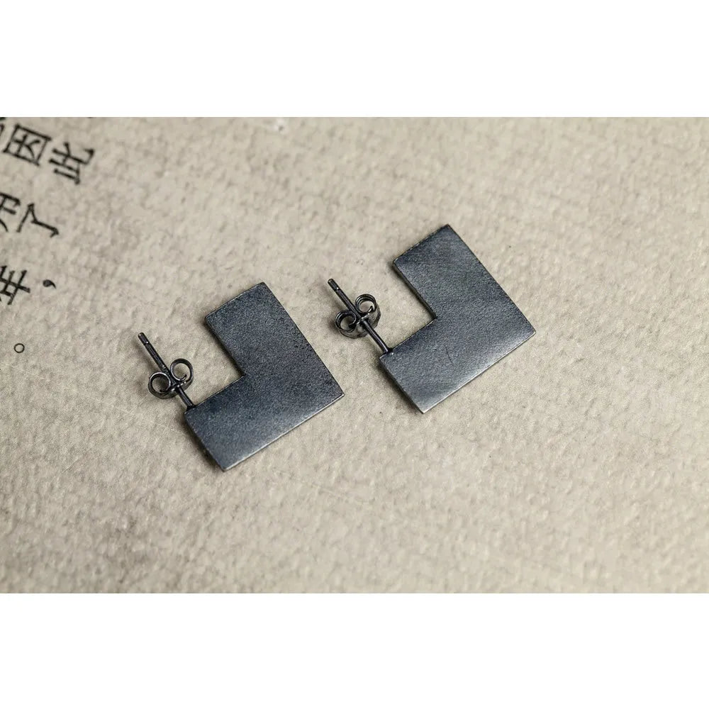 Oxidised black geometric square sterling silver earrings on a white background.