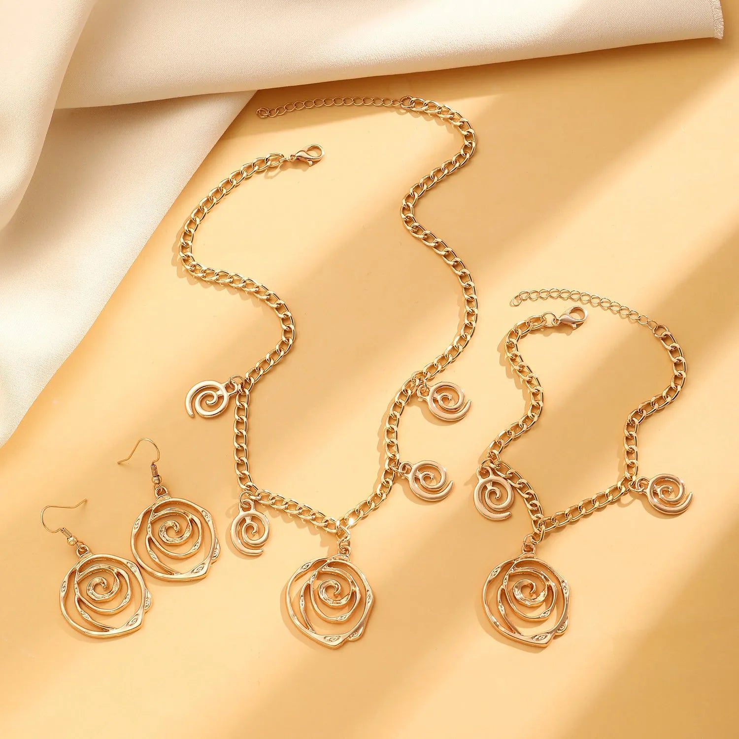 Spiral donut design jewellery set with necklace, bracelet and earrings in gold electroplated alloy
