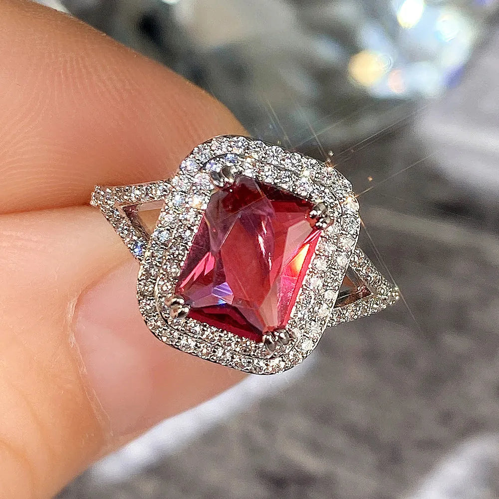 Women's copper square ring with a large red rhinestone centre on a hand.