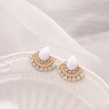 Silver retro fan-shaped stud earrings with rhinestone and opal details on a grey background.