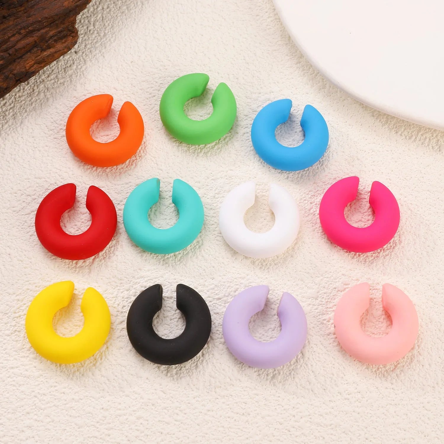 A pair of matte finish, coarse round C-shaped clip-on earrings for women in a choice of fifteen candy colours.