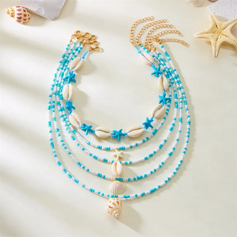 Five women's fashion necklaces with starfish and shell bead designs in blue and multicolour options