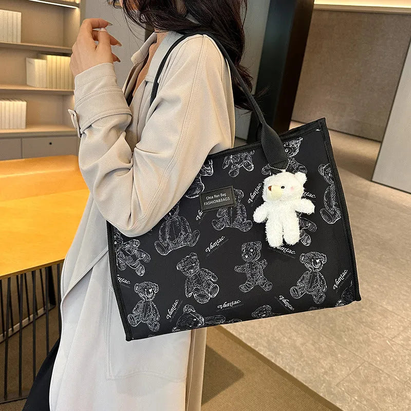 Women's black and white printed canvas tote bag with sandwich pocket and large capacity.