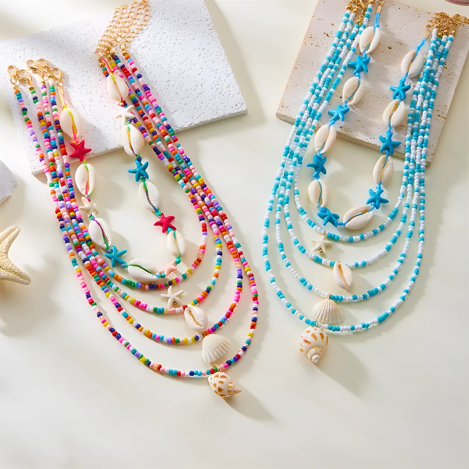 Five women's fashion necklaces with starfish and shell bead designs in blue and multicolour options