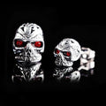 Retro skull stud earrings with ghost head design and red eye detail on alloy background