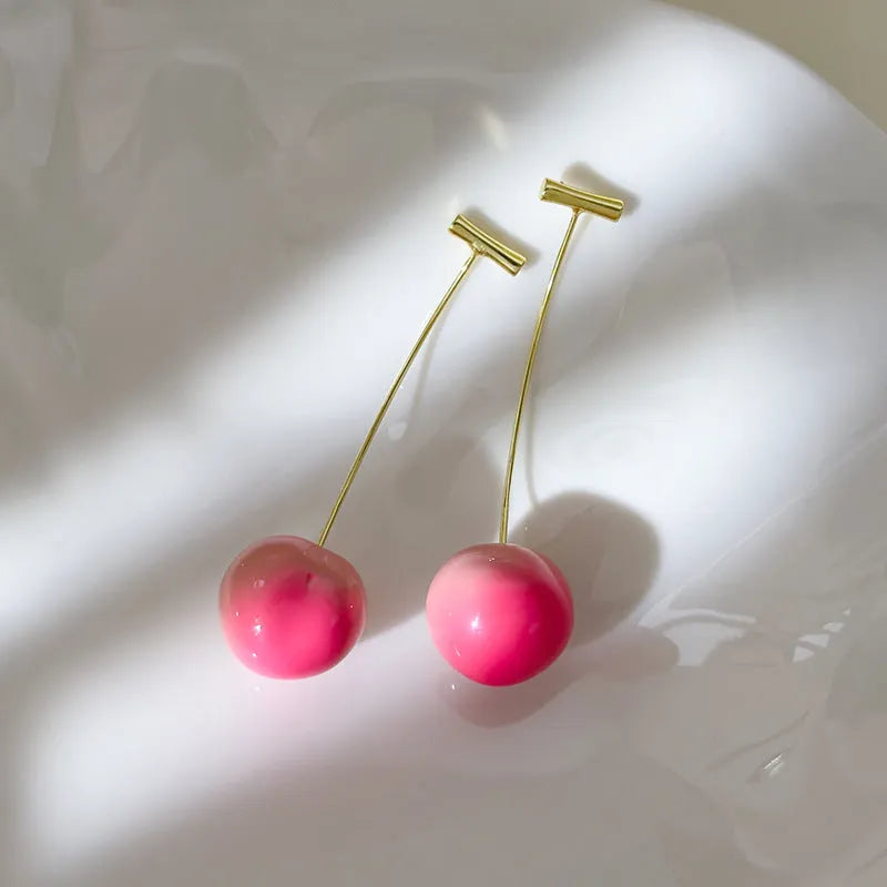A pair of lightweight acrylic earrings shaped like peaches, shown in small and large size options.