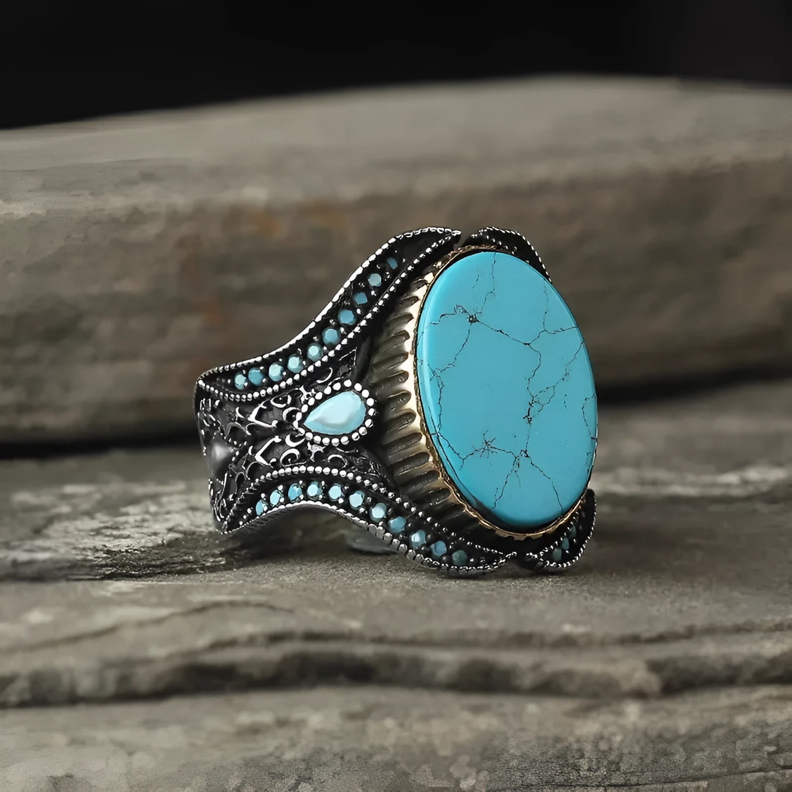 Men's round turquoise-style ring in antique silver alloy on a plain background.