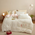 Winter milk fibre princess-style bedding four-piece set with green Christmas tree pattern on a bed.