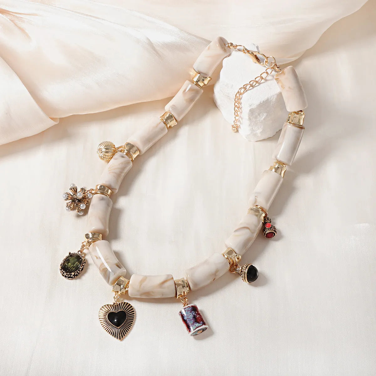 Heart-shaped resin and plastic pendant necklace with an electroplated finish for women.
