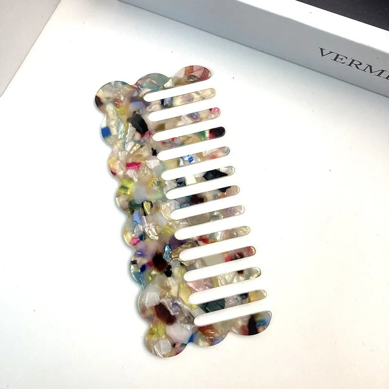 Acetate geometric wave hairdressing comb in pink on white background, 12 cm length