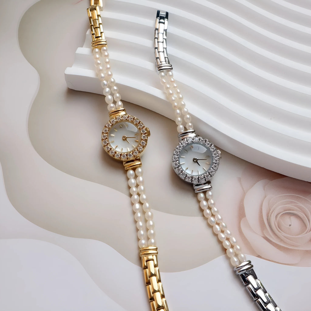 Women's light gold bracelet watch with freshwater pearls and a small round dial.