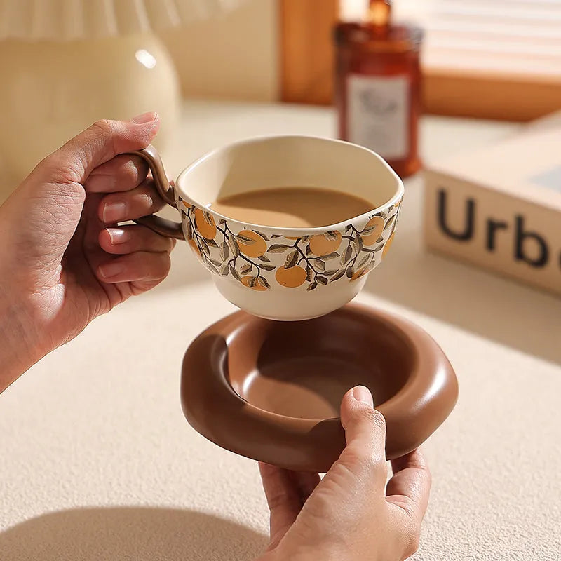 Antique-style black ceramic coffee cup and saucer set on a wooden table