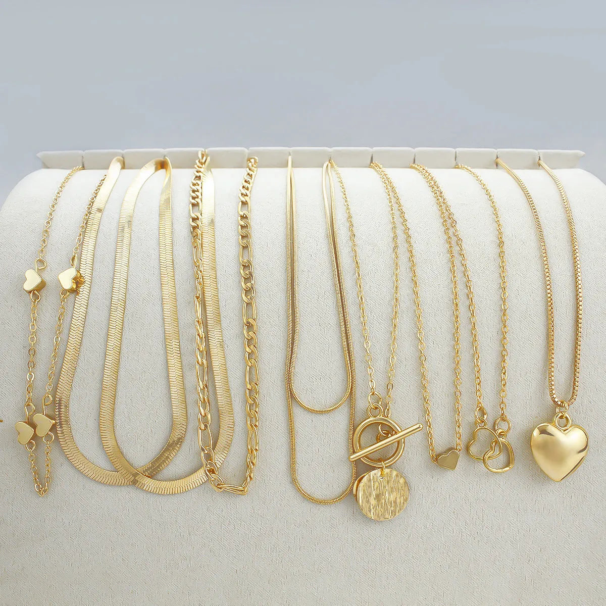 Women's gold necklace set with 10 pendant pieces on adjustable snake bone chain