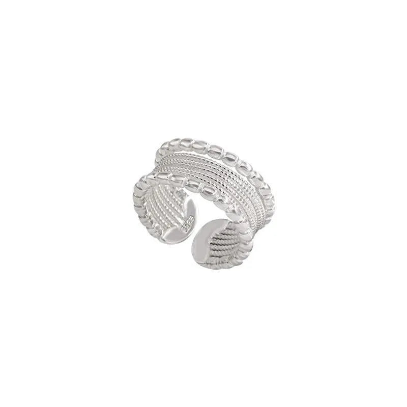 Copper-coloured geometric alloy ring with woven twisted texture and adjustable band.