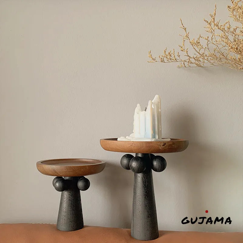 High-legged round wooden tray in a modern Nordic style for candle and decor display.
