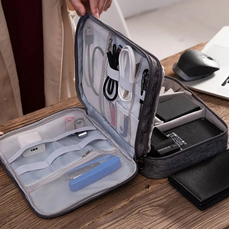 Gray waterproof double-layer electronics organizer bag with adjustable dividers and carrying handle, open to show elastic loops and mesh pockets