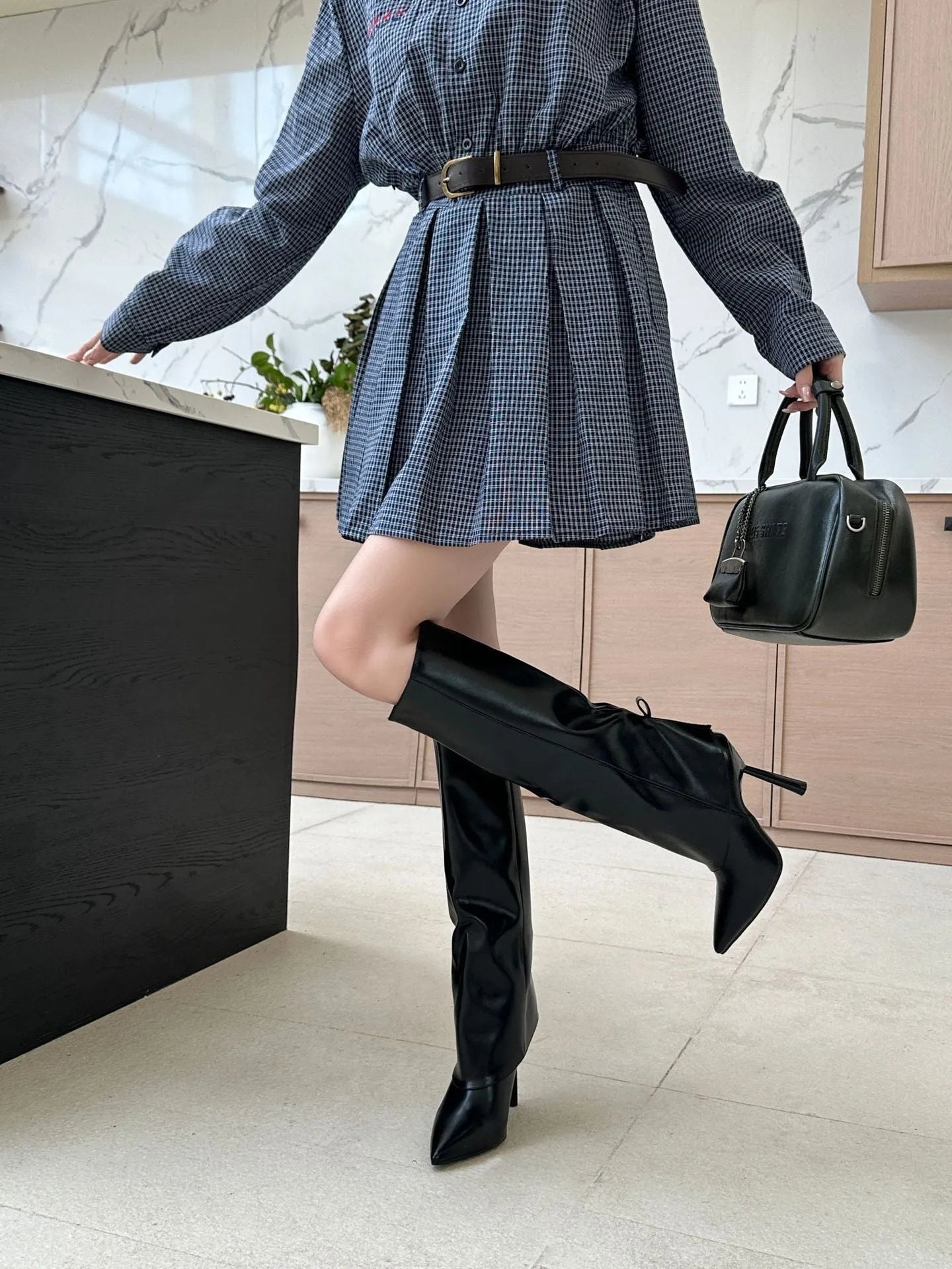 Black slimming leg warmer overshoe boot covers with flanging trim on a high-heeled shoe.