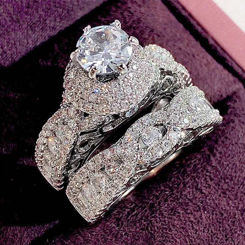 Pair of white gold colour copper couple rings with inlaid zircon stones, geometric U-shaped design on white background