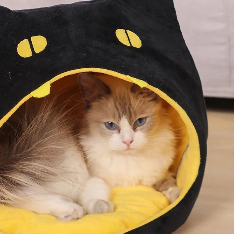 Grey cat-shaped covered pet bed with a removable cushion, shown on a wooden floor.