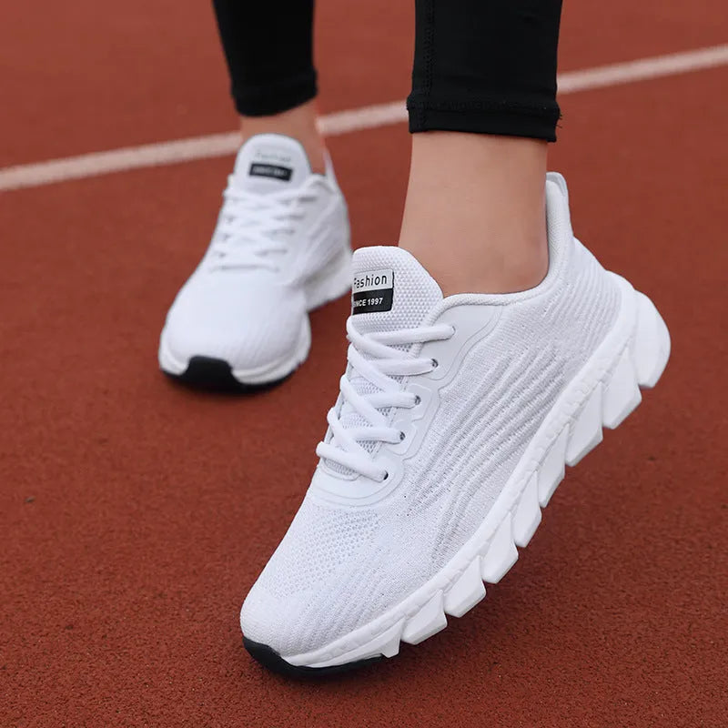Women's low-top platform running sneakers in black and white colours with round toe and cross strap design