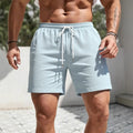 Man wearing loose-fit straight-leg track shorts in a solid colour, showing casual sports style.