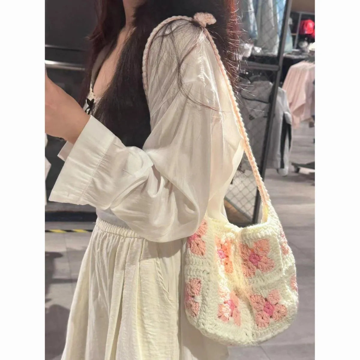 Handmade pink crochet handbag with cherry blossom design and magnetic buckle.