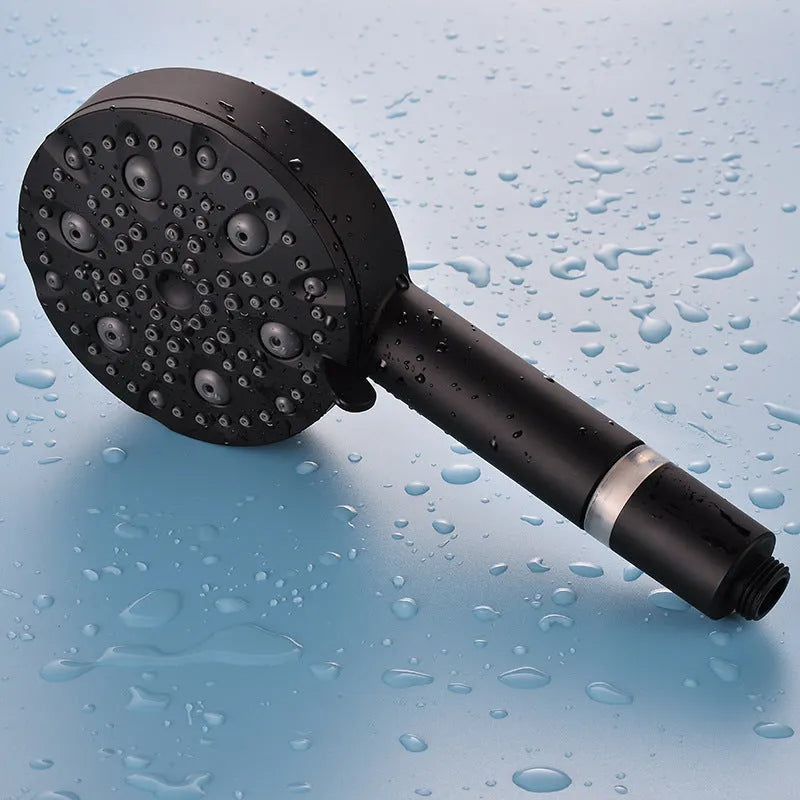 Dark matte black hand-held shower head set with filter, bracket, and hose on a white background