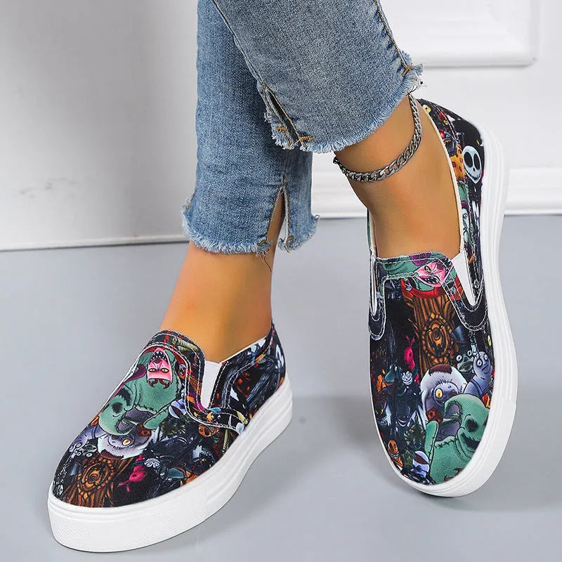 Women's low-top canvas trainers in blue, green, black and colourful designs on a flat rubber sole.