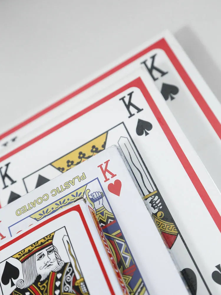 Set of oversized large size paper playing cards laid out on a table, showing the full 54-sheet deck.