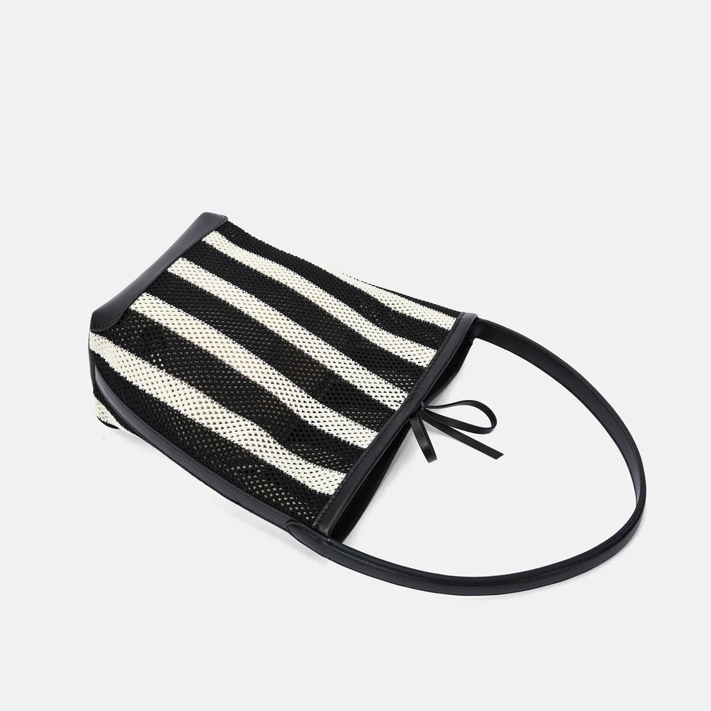 Black and white striped woven shoulder bag with bucket shape showing dimensions