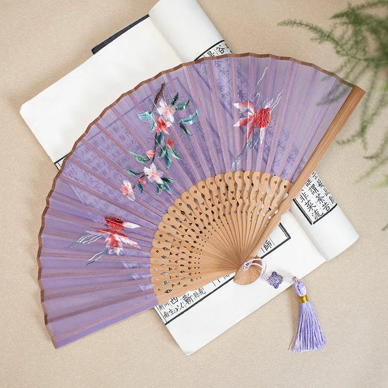 Bamboo frame silk embroidered folding fan showing intricate traditional patterns with folded and open positions
